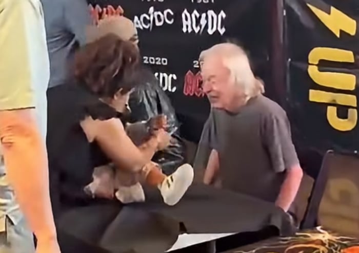 Angus Young (AC/DC) autografa bebê no Canadá